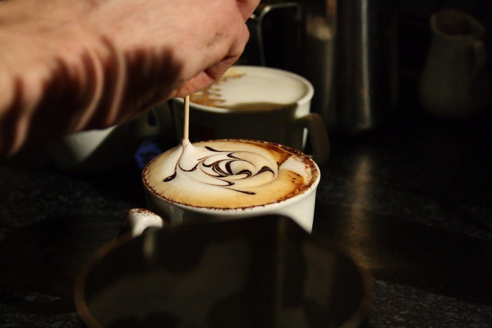 man pouring cream in a coffee
