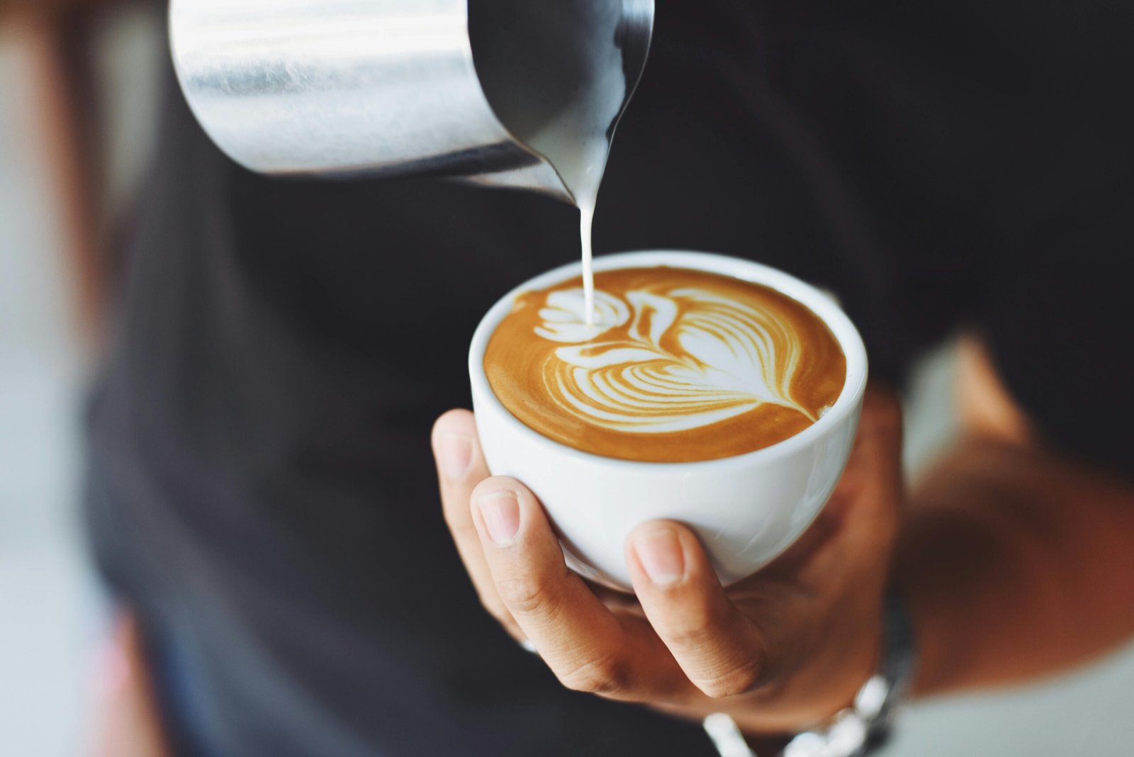 man pouring coffee in cup